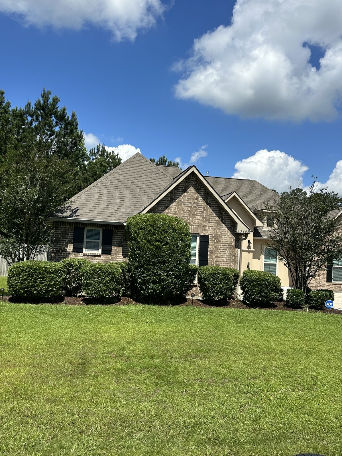 Freshly cut lawn and trimmed shrubs at a brick home in the Hammond area